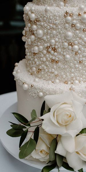 White iced four tier wedding cake with pearl design