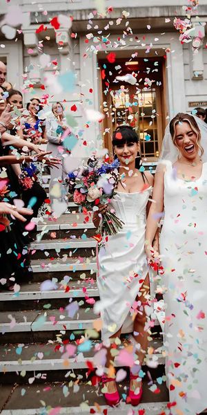 Colourful confetti exit on steps at town hall wedding