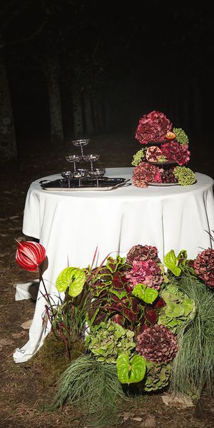 Burgundy and green colour trend wedding flowers on oval table