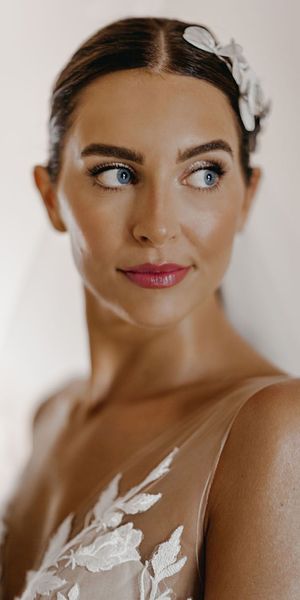 Bride with a pink lip and glittery eyeshadow smiling for wedding