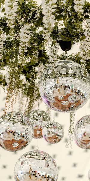 Disco balls and plants hanging from the ceiling, engagement party decoration idea