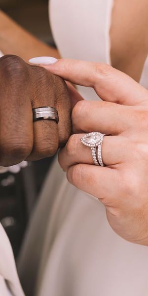 Bride and groom showing off new wedding bands with lab grown diamond engagement ring for bride