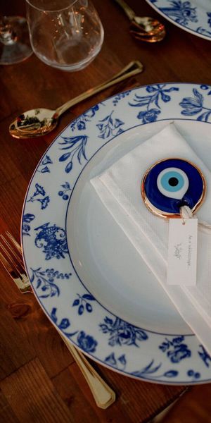 White and blue china plates with evil eye decorative charm on napkin