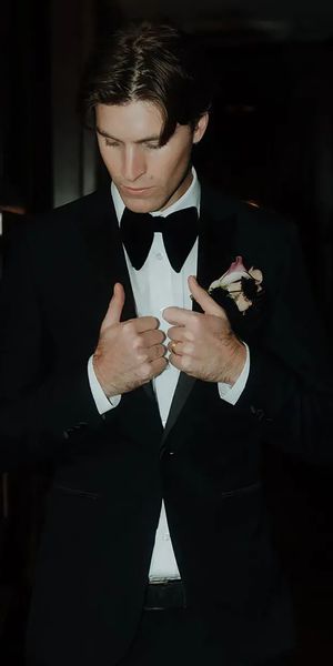 Groom wearing a black wedding suit and bowtie