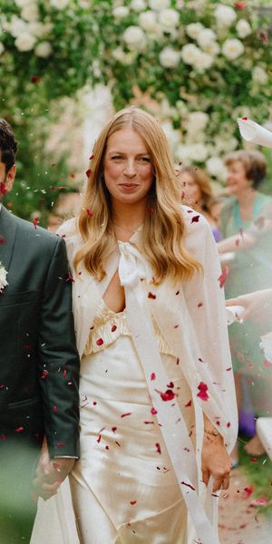 Bride and groom walk through thrown confetti