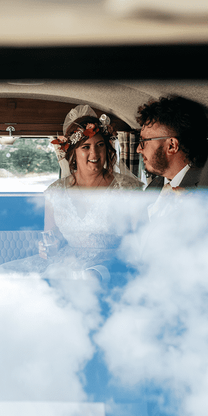 Bride and groom in their Volkswagen campervan after getting married on a sunny day