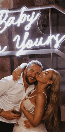 A gorgeous couple in front of their Neon Daddy LED Neon Sign