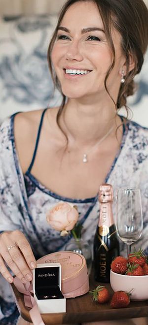 woman-in-floral-pyjamas-opens-gifts-with-champagne-and-jewellery