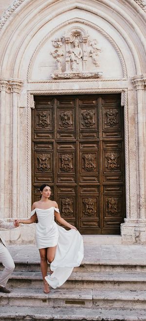 Destination wedding in Italy with bride wearing a short wedding dress and groom wearing neutral beige suit