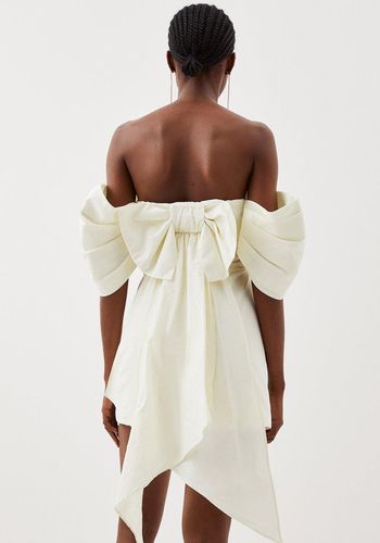 Short beach wedding dress from Karen Millen in ivory with off the shoulder puff sleeves and oversized bow detail at the back