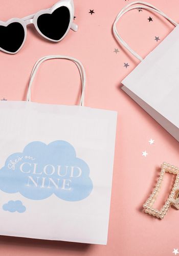 On Cloud Nine theme white gift bags with blue writing for hen party guests 