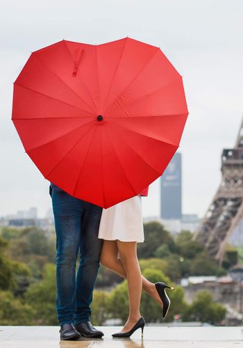 couple-behind-red-heart-shaped-umbrella-eiffel-tower-paris.jpg