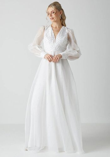 long sleeve princess wedding dress crafted from organza with sheer sleeves and pearl embellishments.