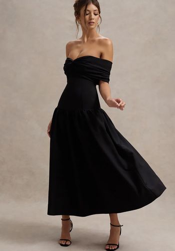 black winter wedding guest dress with figure-skimming silhouette, contemporary drop waist, and twisted bardot neckline. 