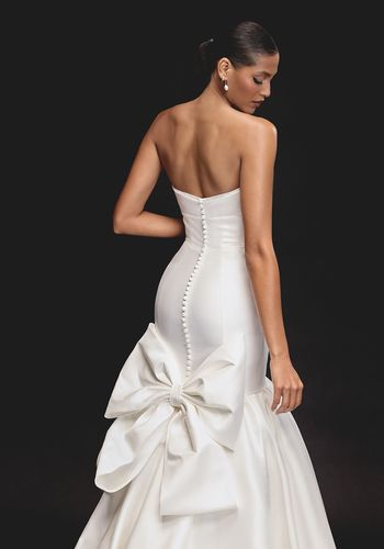 trumpet wedding dress with sweetheart neckline, statement bow on the back, and chapel length train.