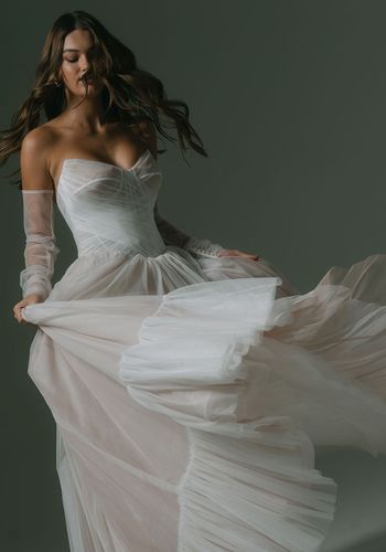  soft tulle wedding dress in blush, featuring basque waistline and peaked cup