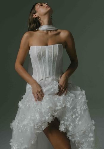 bridal two piece, including corset with exposed boning provides flattering lines. Skirt with 3D beaded lace trailing down the train, and short bubble front. 