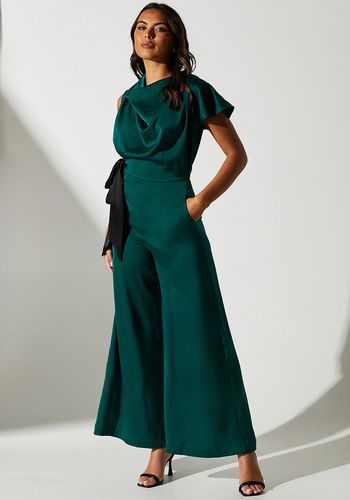 green satin wedding guest jumpsuit with cowl neckline, wide-leg silhouette and short flutter sleeves.