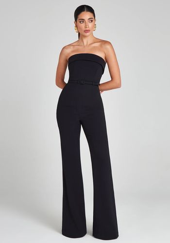 black fit and flare wedding guest jumpsuit in crepe fabric, featuring a bandeau neckline, detachable straps and belt.