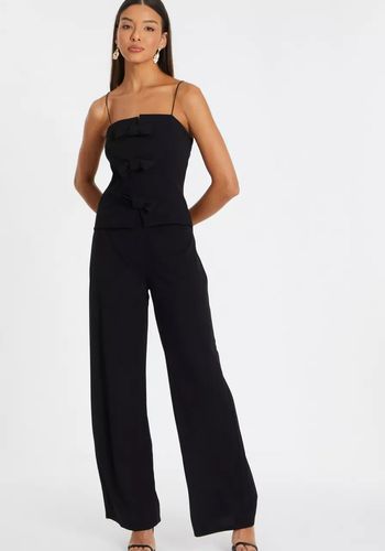 black wedding guest jumpsuit with bow detailing on bodice.