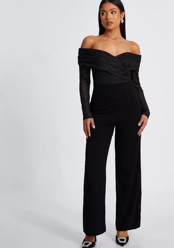 petite wedding guest jumpsuit in black with glitter mesh section, bardot neckline and long sleeves.