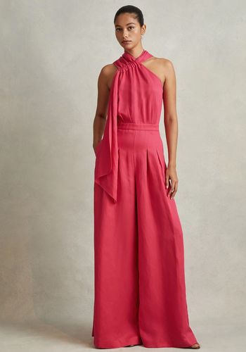 linen wedding guest jumpsuit in coral with halter neckline.