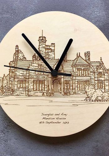 hand drawn illustration of a wedding venue etched onto a wooden clock face and personalised with the wedding details