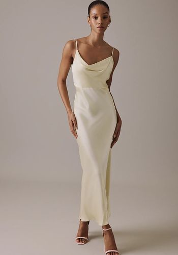 butter yellow slinky slip is framed by barely-there straps and a soft cowl neckline