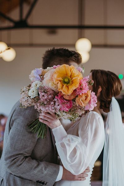 Colourful spring bouquet with orange giant poppy flower for festival theme wedding at Loft Studios. 