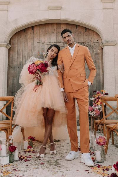 Orange wedding theme with the bride and groom in orange wedding outfits.