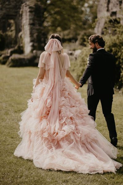 Blush pink coloured wedding dress and bow veil