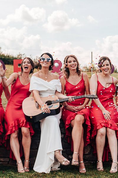 Bride in an ASOS wedding dress with bridesmaids in bright red dresses.