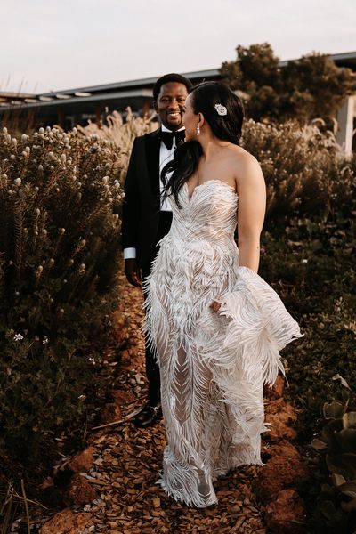 Couture wedding dress with feathers for a luxury, black-tie wedding in South Africa with peach and gold decor and flowers