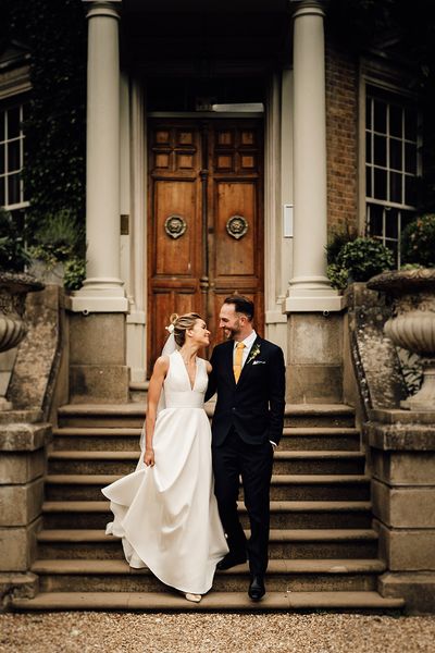 Hampton Court House wedding in Surrey with bride and groom posing together.