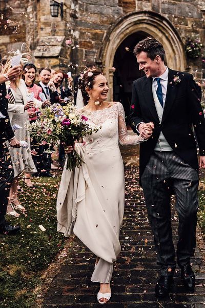 Bride and groom have colourful confetti exit from their church wedding ceremony before going to Wadhurst Castle for their reception.