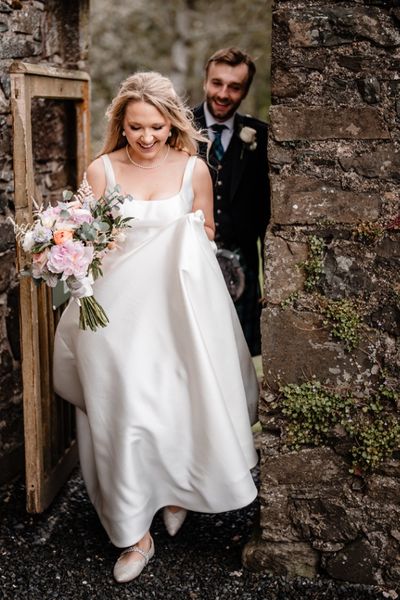 bride and groom walking on castle grounds by dearly photography