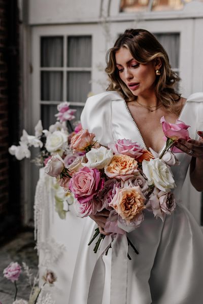 Bride holding a colourful pink and white rose wedding bouquets 