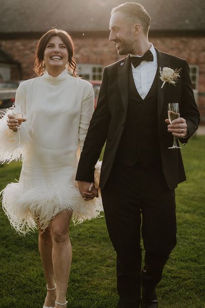 Larkspur Lodge wedding with bride wearing a short feather wedding dress with groom in black tuxedo