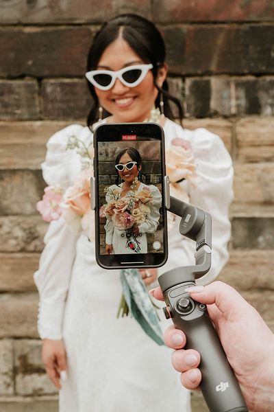 Wedding content creator filming bride with retro sunglasses on