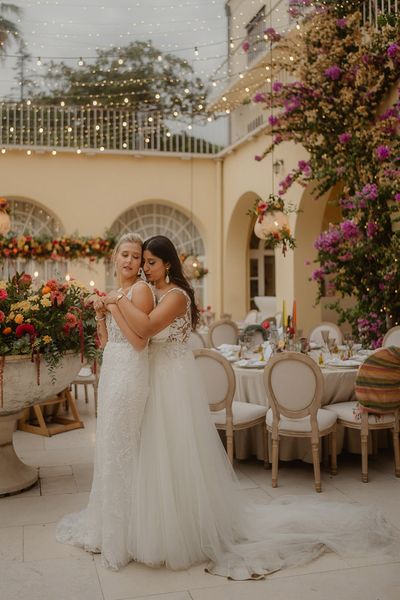 LGBTQIA+ Croatia wedding with two brides in lace wedding dresses and bright wedding flowers