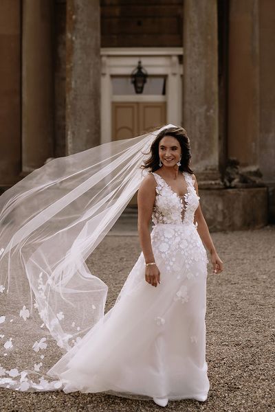 Bride in Mira Zwillinger appliqué wedding dress with floral embroidered veil. 