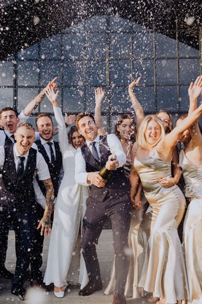 Wedding party pose for a champagne popping picture at The Barn at Botley Hill.