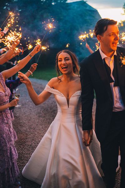 Sparkler exit for bride in sparkly Pronovias dress and groom in black tie for classic wedding including elegant mint green bridesmaid dresses.