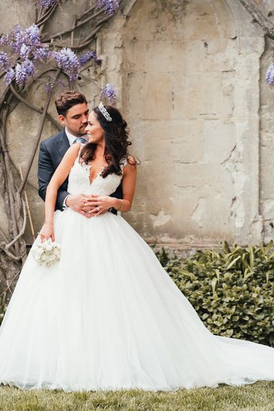 Bride in Pronovias princess wedding dress with groom in front of Kirtlington Park House wedding venue. 