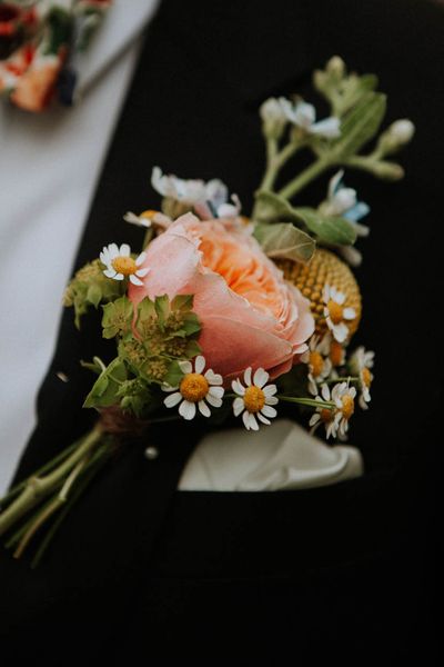 Roundup of stylish groom buttonholes with fresh and dried flowers, foliage, feathers and pins.