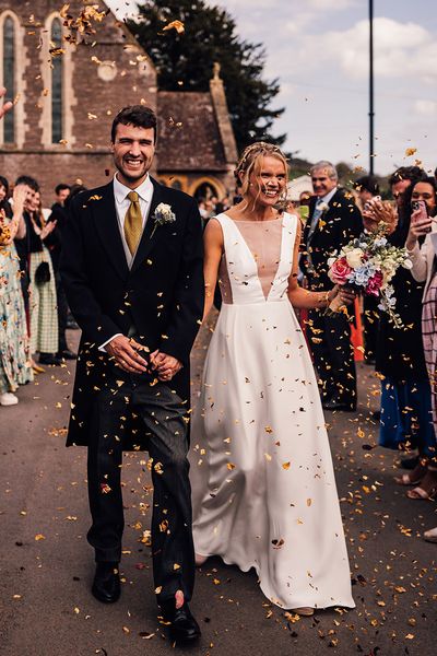 Bride walking with the groom out to confetti in a Andrea Hawkes wedding dress.