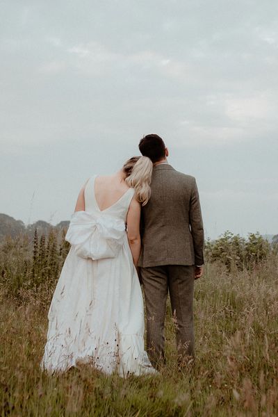 Bride wearing a wedding dress with bow and groom in three piece suit for Middleton Lodge wedding.