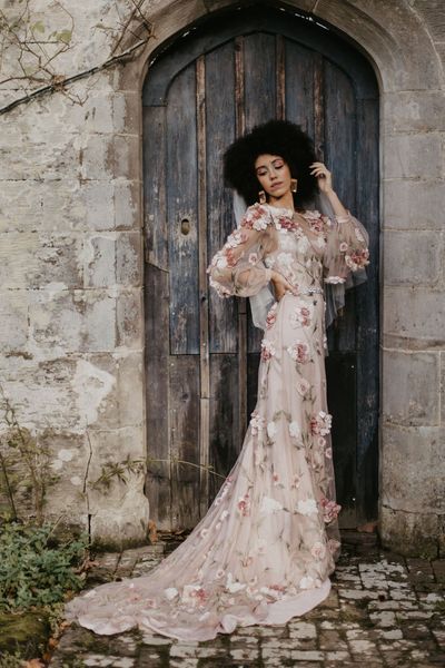 Black bride with afro hair in a 3D flower pink embroidered wedding dress at Chiddingstone Castle