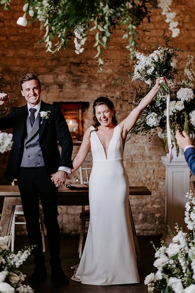 bride and groom exit form their ceremony at their barn wedding