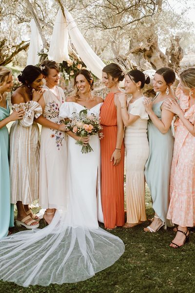 Bride with her bridesmaids in mismatched bridesmaid dresses for destination wedding.